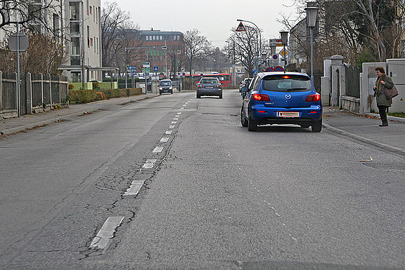 Eine weiße, unterbrochene Linie, die die beiden Fahrbahnhlften voneinander trennt