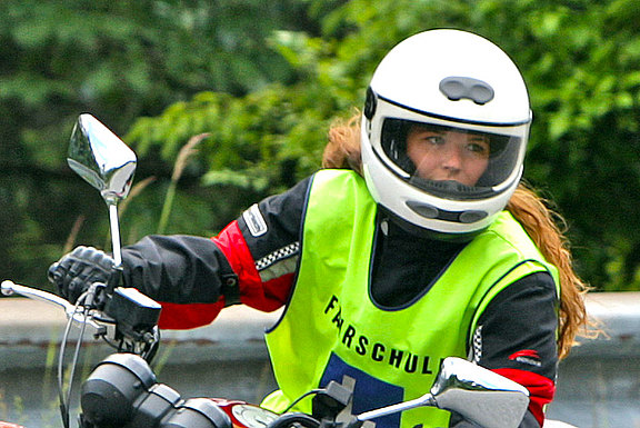 Motorradfahrerin blickt weit in die Kurve