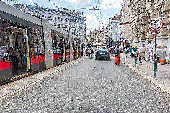 Eine Straßenbahn steht mit geöffneten Türen in der Haltestelle