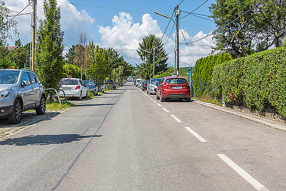 Eine weiße, unterbrochene Linie, die den Parkstreifen von der Fahrbahn abtrennt